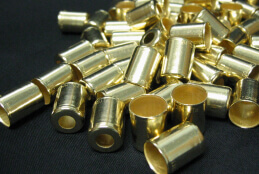 http://A%20group%20of%20small%20polished%20gold%20cylinders%20piled%20on%20a%20dark%20background.