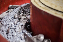 http://Close-up%20image%20of%20metal%20parts%20being%20processed%20in%20a%20vibratory%20finishing%20machine.